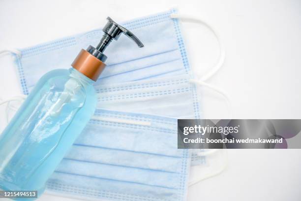 alcohol gel and face mask to prevent virus covid-19 - handdesinfectiemiddel stockfoto's en -beelden