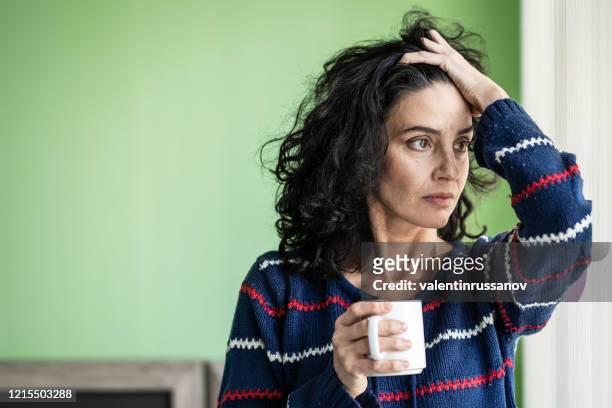 medio volwassen vrouw in isolatie thuis tijdens covid-19 - anxiety stockfoto's en -beelden