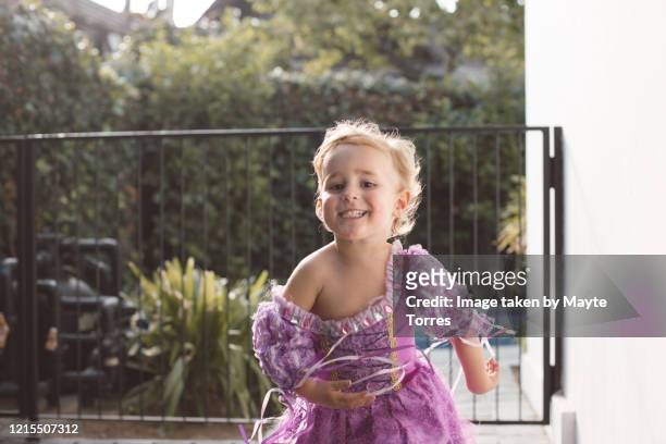 happy excited boy dressed as a princess running towads the camera - jurk stockfoto's en -beelden