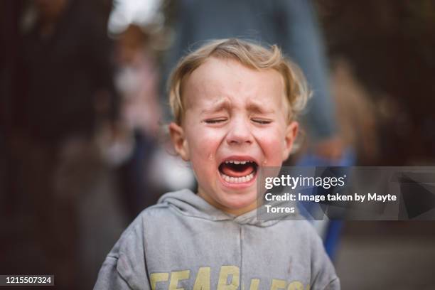 close-up of a crying boy in the street - pianto foto e immagini stock