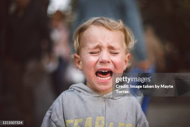 close-up of a crying boy in the street - crying stock pictures, royalty-free photos & images