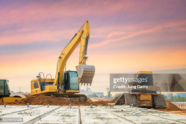 excavator is excavating soil at construction site, project in progress. - tractopelle photos et images de collection