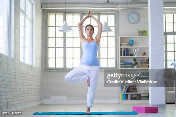 young yogi attractive woman in vrksasana pose - tree position stock pictures, royalty-free photos & images