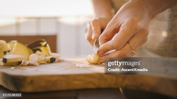 de jonge vrouw bereidt gezonde maaltijd op terras voor - garlic stockfoto's en -beelden