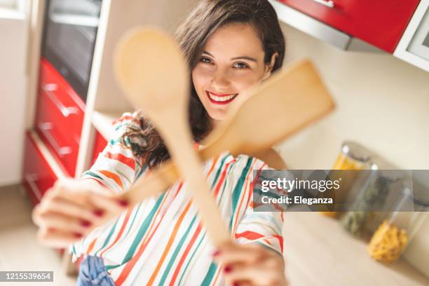 frau hält holzlöffel - junge frau allein stock-fotos und bilder
