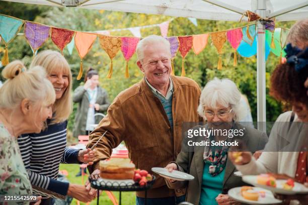 personas mayores disfrutando de la torta - fiesta al aire libre fotografías e imágenes de stock
