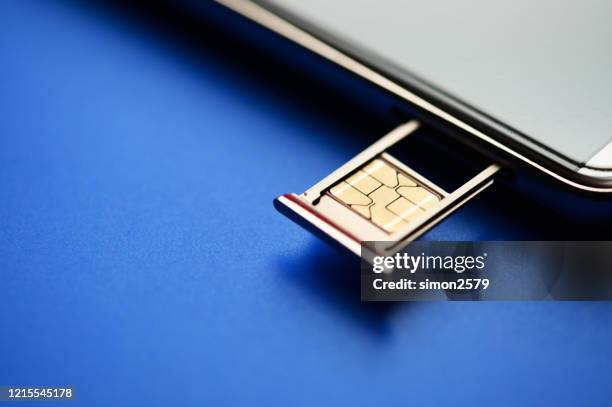 smartphone und sim-karte auf blauem hintergrund - sim card stock-fotos und bilder