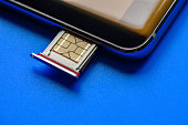 Smart phone and sim card on blue background