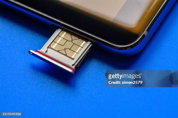 smart phone and sim card on blue background - all sim card stock pictures, royalty-free photos & images