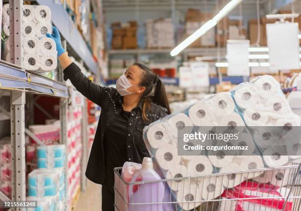 porträt einer reifen frau, die eine schutzmaske trägt und in einem supermarkt einkaufen - megastore stock-fotos und bilder