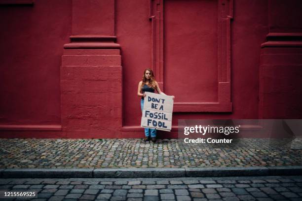 teenage girl holding climate school strike protest sign - klimaschutz stock-fotos und bilder