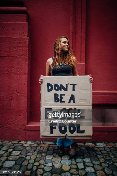 teenage girl holding climate school strike protest sign - protest stock-fotos und bilder
