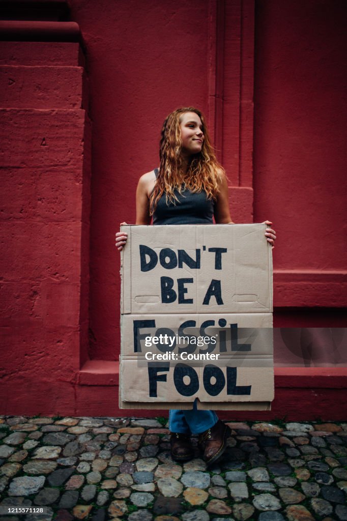 Teenage girl holding climate school strike protest sign