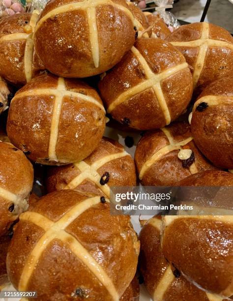 traditional british easter food, pile of freshly baked gourmet organic hot cross buns with raisins - hot cross bun stock pictures, royalty-free photos & images