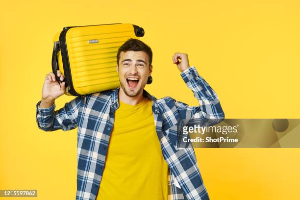 a happy man waited for the weekend, packed his things and went on a trip. - yellow suitcase stock pictures, royalty-free photos & images