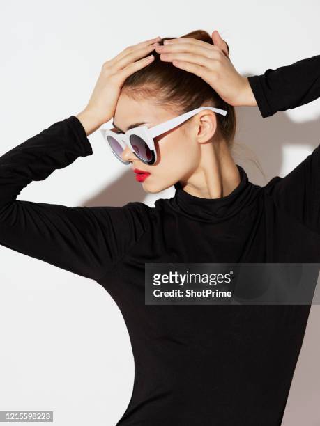 woman holding her head while standing on a white background. - women in see through tops stock pictures, royalty-free photos & images