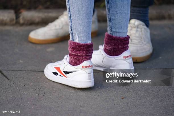 Guest wears ripped skinny jeans, purple velvet chenille socks, Reebok sneakers , outside Sacai, during Paris Fashion Week - Menswear F/W Fall/Winter...