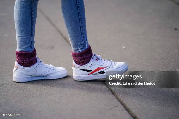 Guest wears ripped skinny jeans, purple velvet chenille socks, Reebok sneakers , outside Sacai, during Paris Fashion Week - Menswear F/W Fall/Winter...