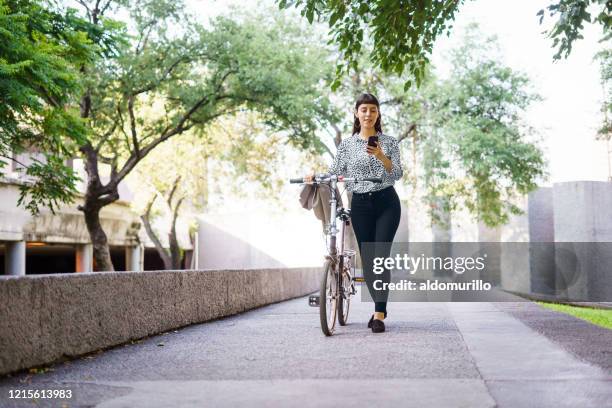 lovely  woman walking with bike and using phone - tree smartphone stock pictures, royalty-free photos & images
