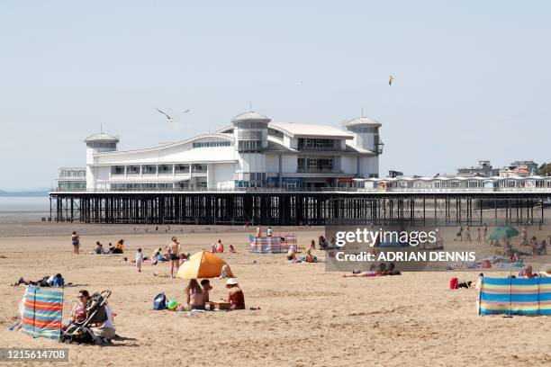 Sunbathers enjoy the warm weather at the beach in Weston-super-Mare, south west England on May 27 as lockdown measures are eased during the novel...