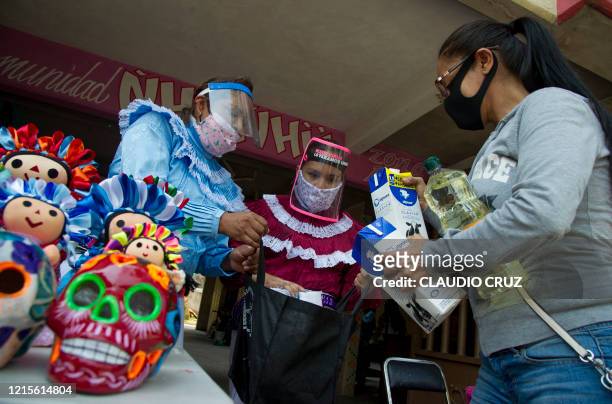 Mariana Gonzalez and Maricela Perez, members of indigenous Otomi ethnic group wear a face shield as a preventive measure against the spread of the...