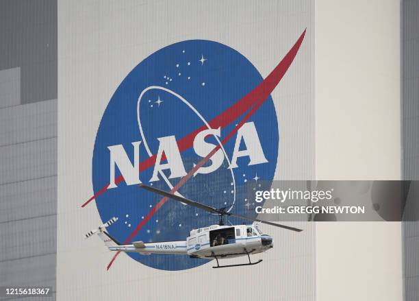 Security helicopter flies past the Vehicle Assembly Building on launch day at the Kennedy Space Center in Florida on May 26, 2020. A new era in space...