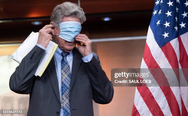 Representative Frank Pallone, Democrat of New Jersey, puts on a mask during a press conference about COVID-19 testing on Capitol Hill in Washington,...