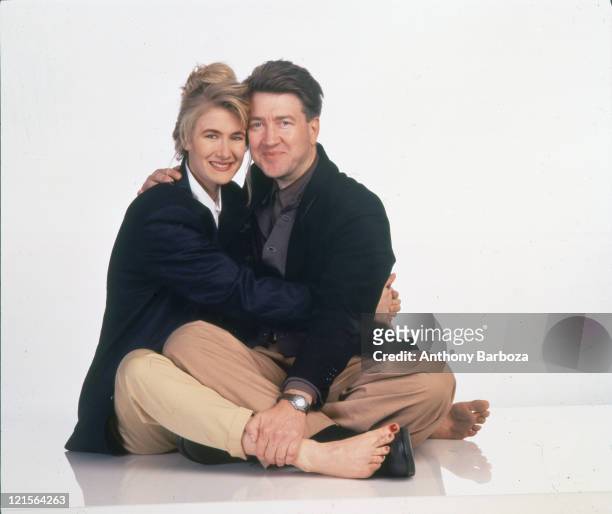Portrait of American actress Laura Dern and film director David Lynch as they embrace against a white background, 1990.