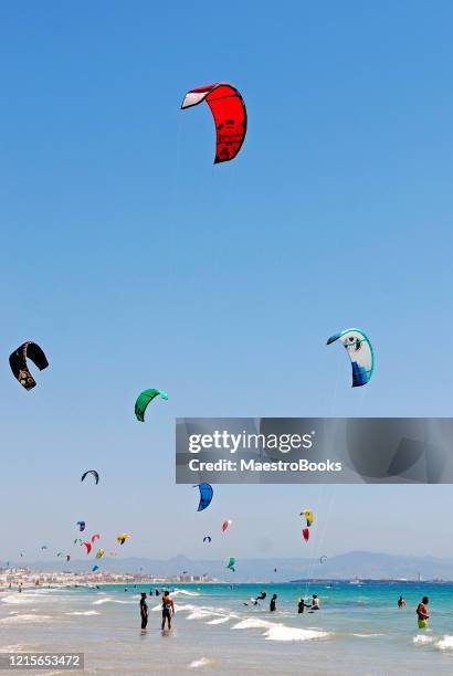 people practising kitesurfing at tarifa beach in south spain - tarifa imagens e fotografias de stock