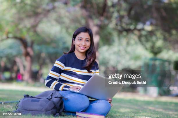 reading a book at park stock photo - indian college girls stock pictures, royalty-free photos & images