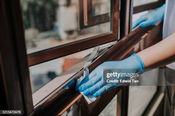 een aziatische chinees wijfje handen met rubberhandschoen die glasvenstergrill afveegt - windowframe stockfoto's en -beelden