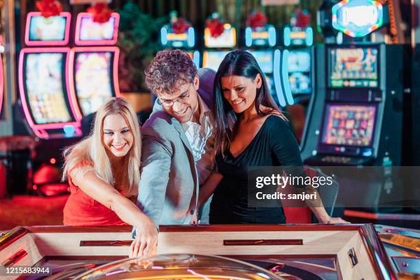 people gambling in the casino - casino interior stock pictures, royalty-free photos & images