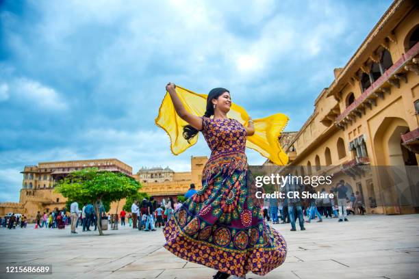 woman dancing inside the courtyard of amber fort, jaipur, rajasthan, india, it is unesco world heritage site. - amber fort stock-fotos und bilder