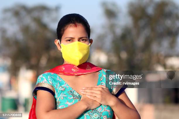 women with chest pain, covering her face with pollution mask for protection against covid-19 - flu mask stock pictures, royalty-free photos & images