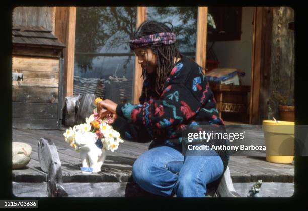 Portrait of American poet and author Alice Walker as she sits, with a pot of flowers on per porch, San Francisco, California, 1989.
