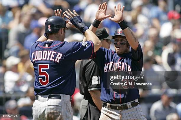 Luis Rodriguez of the Minnesota Twins is congratulated by Michael Cuddyer after scoring against the Kansas City Royals at Kauffman Stadium in Kansas...