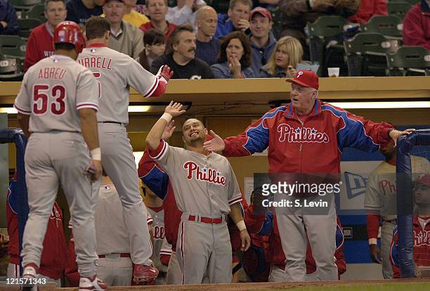 Pat Burrell is given high-fives in the dugout after hitting an early home run during the game between the Milwaukee Brewers and the Philadelphia...