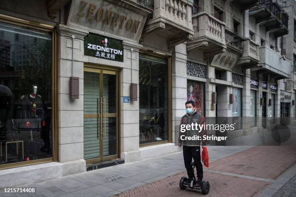 Man uses a segway hoverboard on a street on March 30, 2020 in Hubei Province, China. Wuhan, the central Chinese city where the coronavirus first...