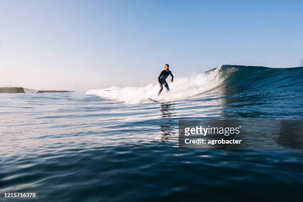 junger mann surfen - big wave surfing stock-fotos und bilder
