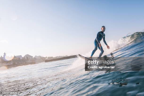 junger mann surfen - big wave surfing stock-fotos und bilder