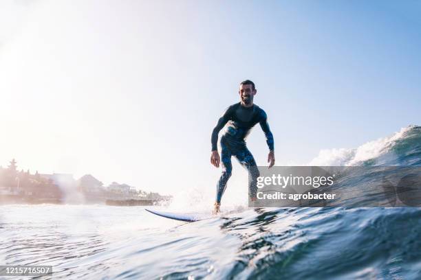 young man surfing - big wave surfing stock pictures, royalty-free photos & images