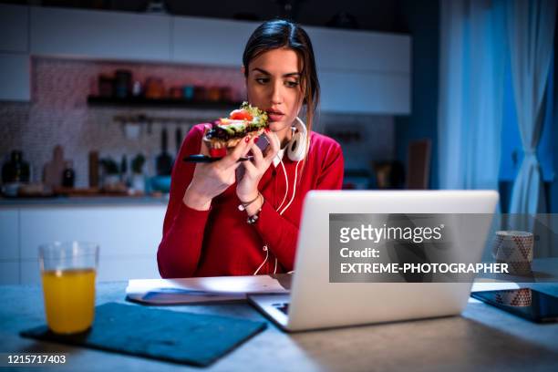 junge frau mit einem sandwich bei der arbeit von zu hause - woman sandwich stock-fotos und bilder