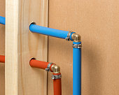 Pex plastic water supply plumbing pipe in wall of house. Concept of home repair, maintenance and remodeling