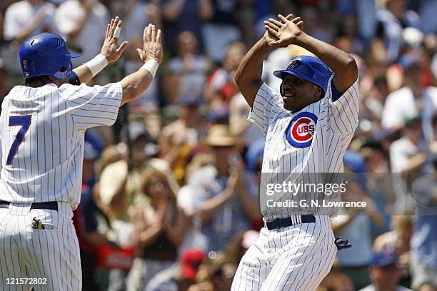 The Cubs Jacque Jones prepares to high-five Todd Walker after scoring during action between the Atlanta Braves and Chicago Cubs at Wrigley Field in...