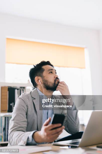 uomo che ascolta il podcast - audiobook foto e immagini stock