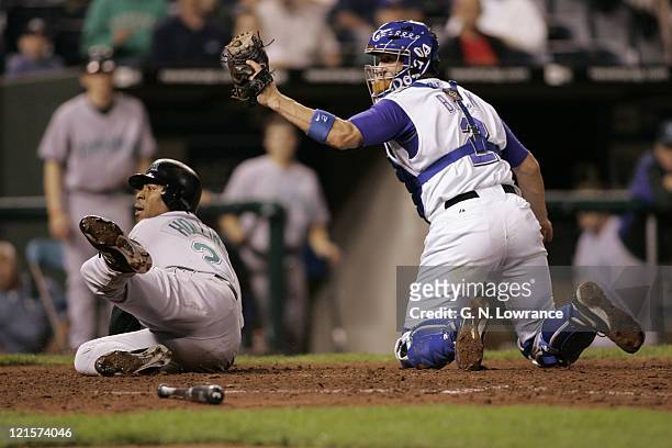 John Buck of the Kansas City Royals and Damon Hollins of the Tampa Bay Devil Rays await the umpires call after a play at the plate at Kauffman...