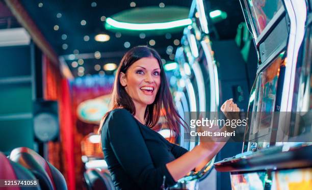 elegant woman winning on a slot machine - slot machine imagens e fotografias de stock