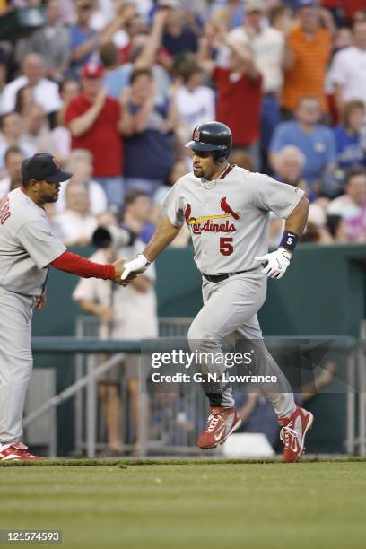 Albert Pujols is greeted by Jose Oquendo during action between the St. Louis Cardinals and Kansas City Royals at Kauffman Stadium in Kansas City,...