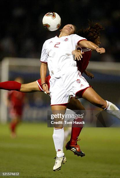 Christine Latham of Canada fights for the ball with a China defender during game action at PGE Park in Portland, Oregon, October 2, 2003. Canada...