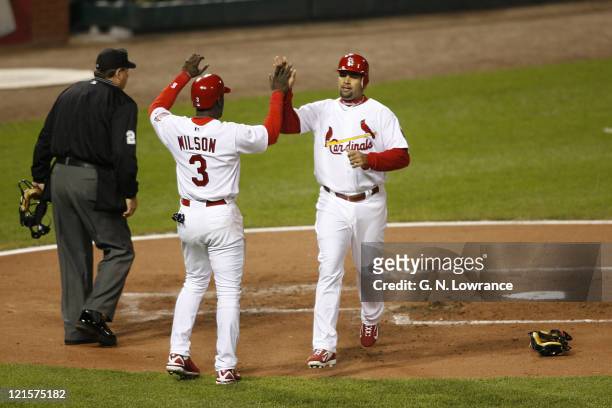 Albert Pujols is congratulated by Preston Wilson after scoring in the 1st inning during game 3 of the NLCS between the New York Mets and St. Louis...